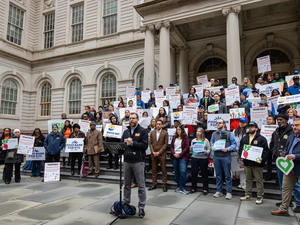 Zac Hall, SVP of Programs, Nutrition Education, speaks with fellow Food Bank For NYC advocates on the steps of City Hall April 2025.