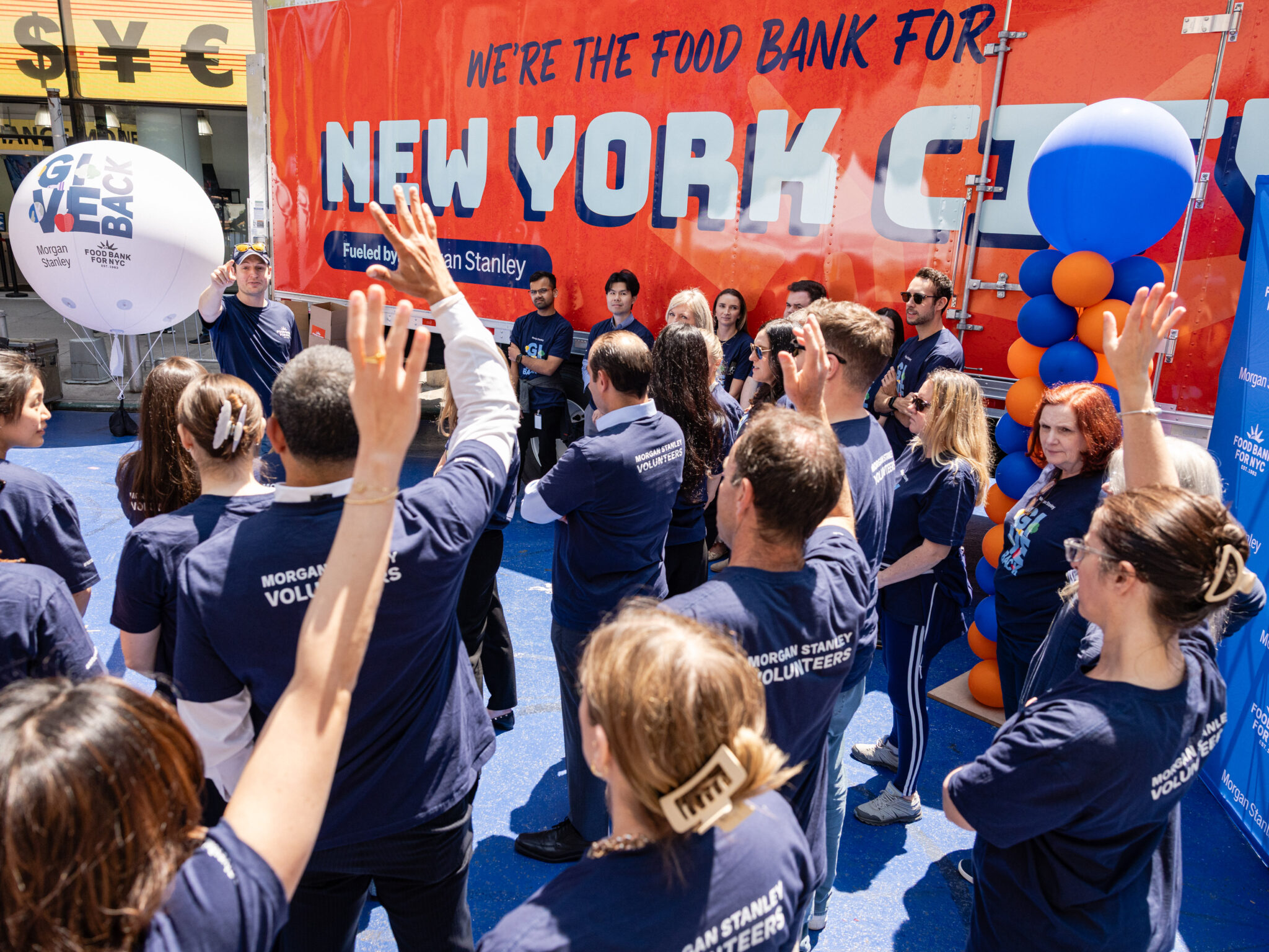 Newly wrapped truck graciously donated by Morgan Stanley reads "We're the Food Bank For New York City" as volunteers cheer.
