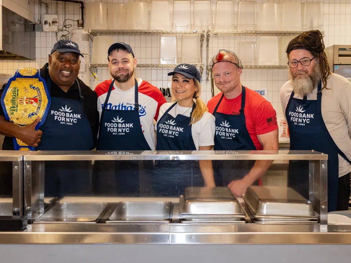 Major League Eaters line up behind the counter to serve senior lunch at the Community Kitchen.