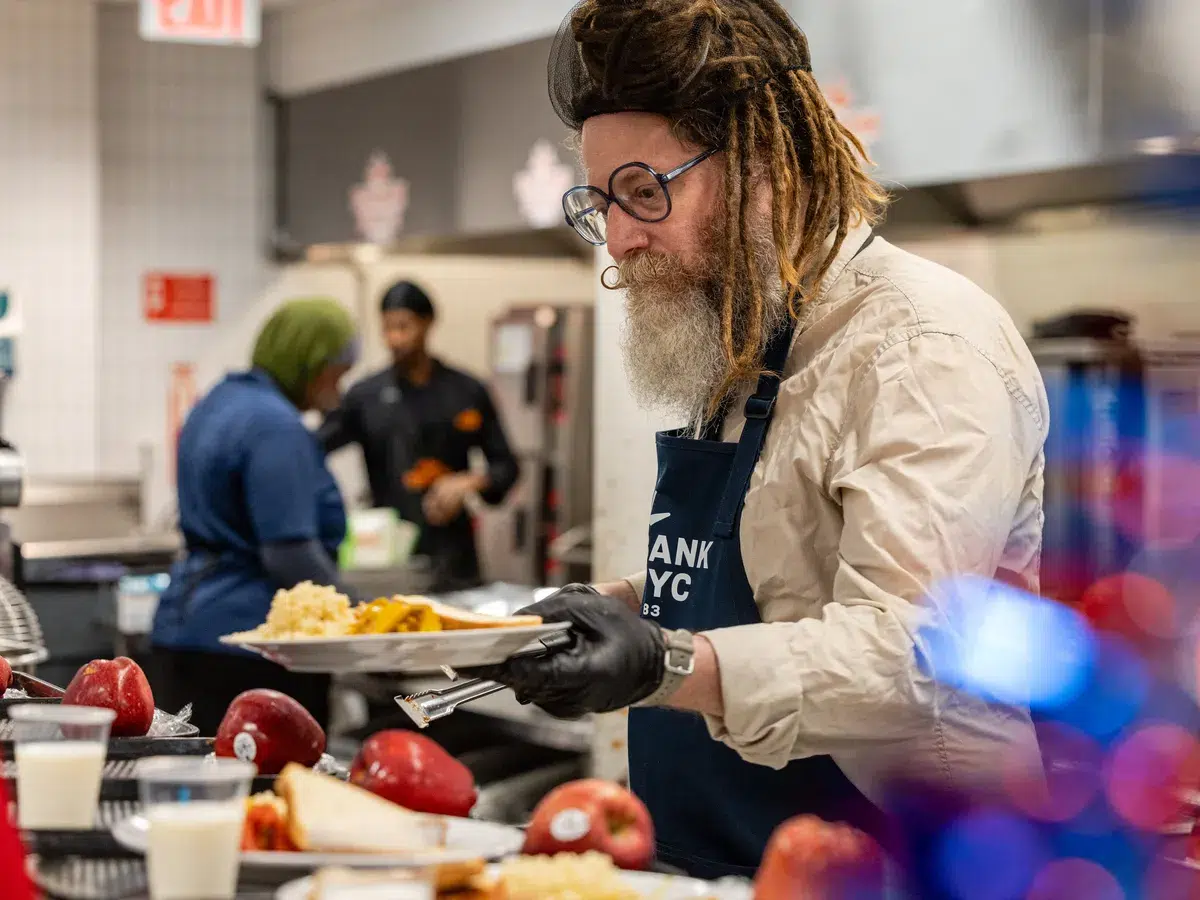 Major League Eater holds a plate of nutritious food at the Community Kitchen.