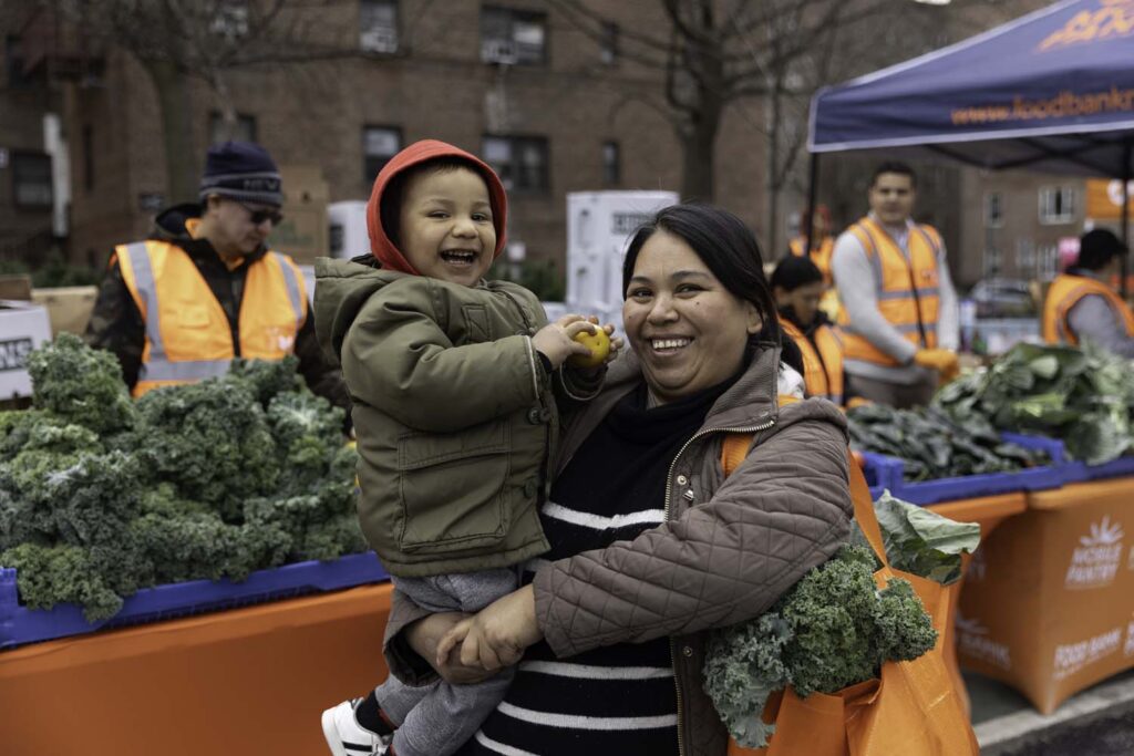 Mother and child receiving essential food items from food pantry