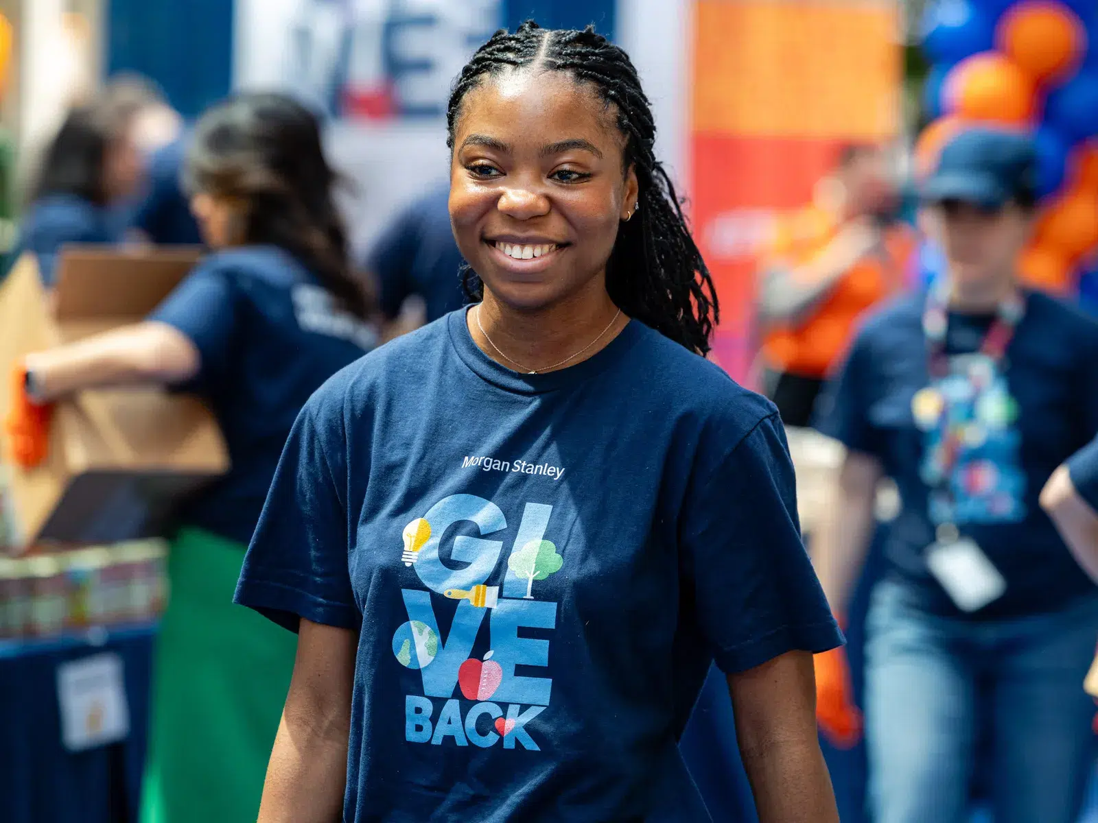 Smiling young woman in a 'Give Back' shirt at a Food Bank for NYC volunteer event