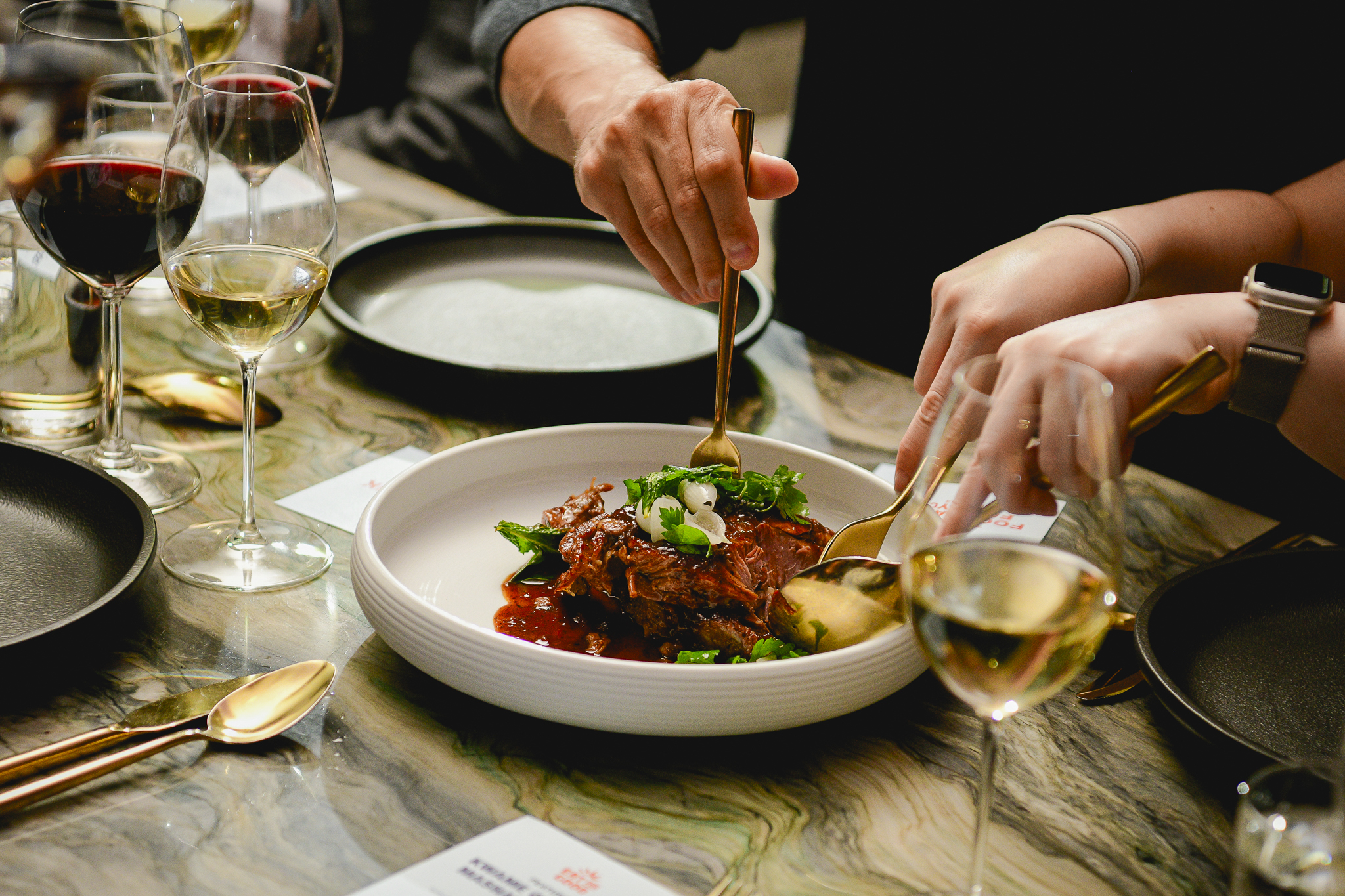 Eat For Good guest cuts through signature plated dish.