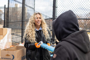 WWE Superstar Maxxine Dupri smiles while handing a New Yorker essentials.