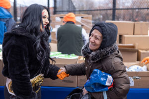 WWE Women's World Champion Stephanie Vaquer laughs while holding a New Yorker's hand.