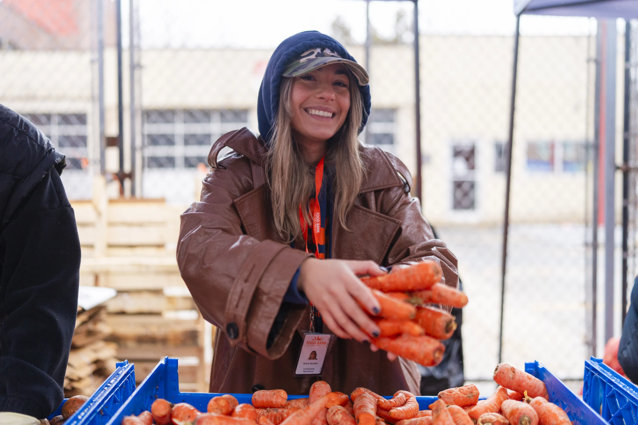 Grace Accetta holds carrots at Food Bank For NYC distribution.