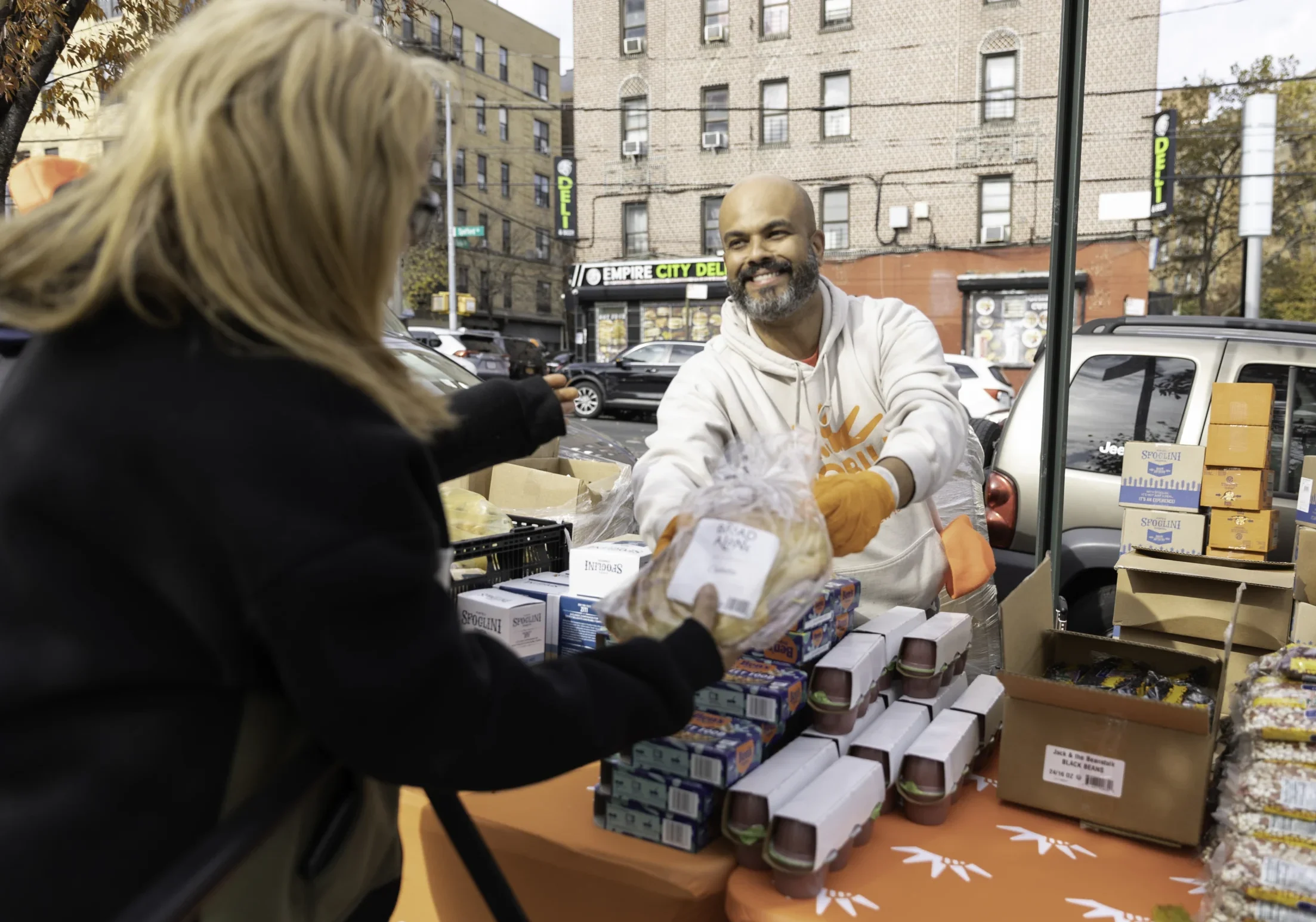 Food Bank For NYC volunteer Miguel hands fresh bread to his neighbor.