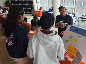 Aaliyah Bartholomew leads a tabling event at Medgar Evers College focused on storytelling, advocacy, and raising awareness around campus food pantry funding.